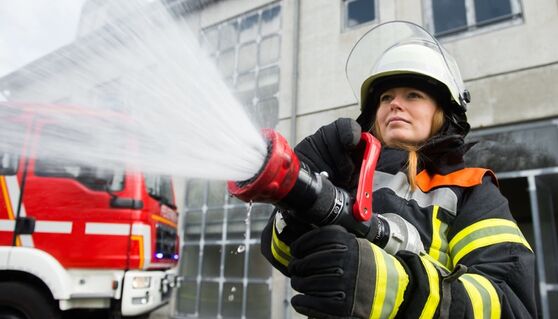 Feuerwehrfrau löscht Feuer (Bild: benjaminnolte/Fotolia)